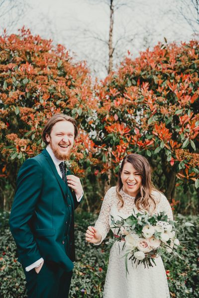 bride and groom laughing and bride holds her wedding flowers, styal lodge wedding photography, styal lodge wedding photographer, manchester wedding photographer, manchester wedding photography, cheshire wedding photographer, cheshire wedding photography