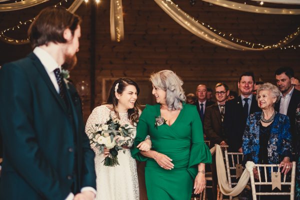 bride laughing whilst looking at her mum who is walking her up the ailse to her husband who is waiting for her, styal lodge wedding photography, styal lodge wedding photographer, manchester wedding photographer, manchester wedding photography, cheshire wedding photographer, cheshire wedding photography