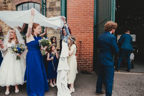 bride and bridal party stand under a white sheet and groomsmen open the door, elsecar heritage centre wedding photographer, elsecar heritage centre wedding photography, elsecar heritage centre wedding, ayesha photographer, manchester wedding photographer, manchester wedding photography, sheffield wedding photographer, sheffield wedding photography, barnsley wedding photographer, innercity weddings