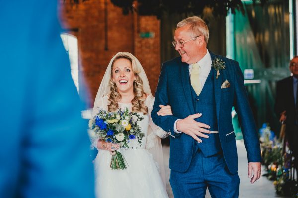 bride and dad walk up the ailse and bride smiles at groom whilst holding her flowers and linking her dads arm, elsecar heritage centre wedding photographer, elsecar heritage centre wedding photography, elsecar heritage centre wedding, ayesha photographer, manchester wedding photographer, manchester wedding photography, sheffield wedding photographer, sheffield wedding photography, barnsley wedding photographer, innercity weddings