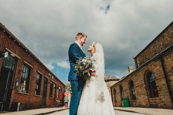 bride and groom look at each other whilst stood in the street at the elsecar centre, elsecar heritage centre wedding photographer, elsecar heritage centre wedding photography, elsecar heritage centre wedding, ayesha photographer, manchester wedding photographer, manchester wedding photography, sheffield wedding photographer, sheffield wedding photography, barnsley wedding photographer, innercity weddings