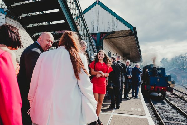 wedding guests stand on platform waiting for steam train, elsecar heritage centre wedding photographer, elsecar heritage centre wedding photography, elsecar heritage centre wedding, ayesha photographer, manchester wedding photographer, manchester wedding photography, sheffield wedding photographer, sheffield wedding photography, barnsley wedding photographer, innercity weddings