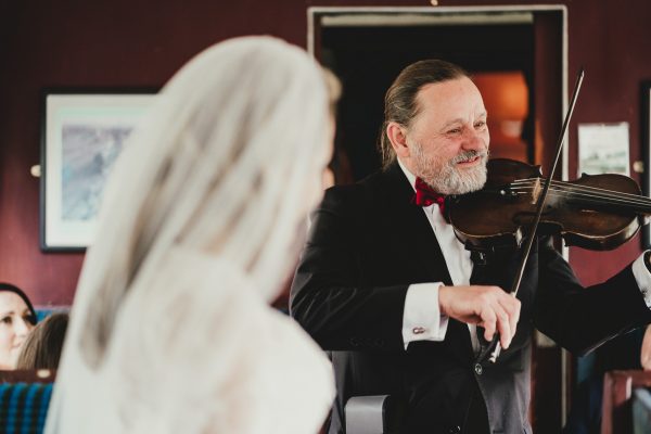 violinist plays on the train with the bride looking on, elsecar heritage centre wedding photographer, elsecar heritage centre wedding photography, elsecar heritage centre wedding, ayesha photographer, manchester wedding photographer, manchester wedding photography, sheffield wedding photographer, sheffield wedding photography, barnsley wedding photographer, innercity weddings